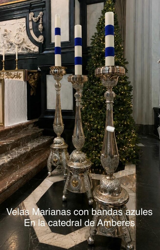 Altas velas marianas blancas con bandas azules sobre candelabros plateados ornamentados en la catedral de Amberes