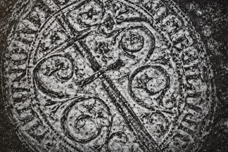 Sello medieval de los Hermanos de la Espada con una cruz y ornamentos en piedra desgastada