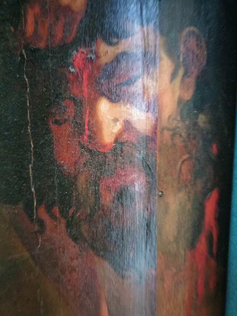 Detail van een beschilderd orgelluik van het rugwerk, met het nog bloedende hoofd van Goliath als onderdeel van Davids overwinningstocht.