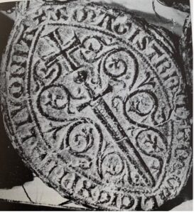 Sceau médiéval des Frères de l’Épée avec une croix et des ornements dans une pierre usée