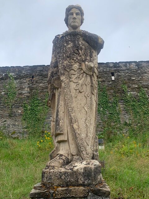 Stenen standbeeld van Godfried van Bouillon, met zijn kasteel op de achtergrond.