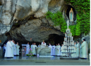Heilige Mis bij de grot van Lourdes met priesters en gelovigen voor het Mariabeeld in de rotsnis