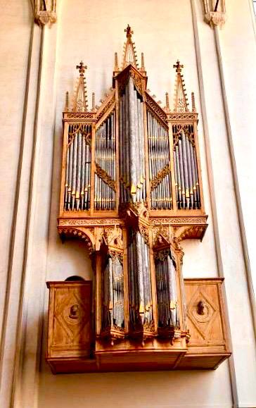 Vijftiende-eeuwse orgelkas van het Peter Gerritsz-orgel, hoog aan de kerkmuur in Middelburg geplaatst, met een slanke gotische houten kas, meerdere verticale pijpvelden en rijk uitgesneden spitsbogen en pinakels.