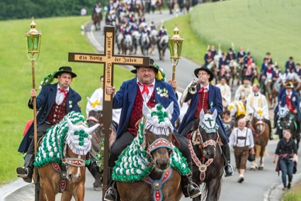 Ruiterprocessie tijdens Pinksteren met kruisdragers en pelgrims te paard in Duitsland of Slovenië.